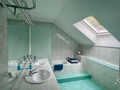 baño con 2 lavabos, bañera y tragaluz en Palm Maresme - Suite with bathroom and living-room and terrasse with ocean views in a private villa en Vilassar de Dalt