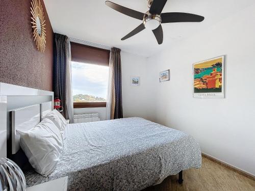 um quarto com uma cama e uma ventoinha de tecto em LETS HOLIDAYS SEA VIEWS APARTMENT & POOL in SA GABARRA em Tossa de Mar