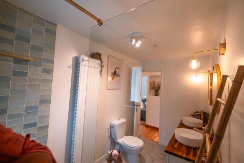 a bathroom with two sinks and a toilet and a shower at L'écrin de Bruniquel in Bruniquel
