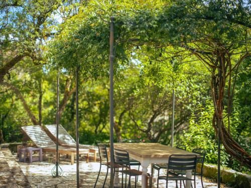 a table and chairs sitting under a tree at L'écrin de Bruniquel in Bruniquel
