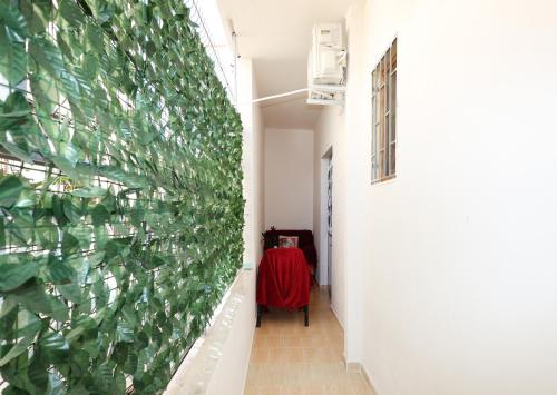 a hallway with a wall covered in green leaves at Berat Central Apartment in Berat
