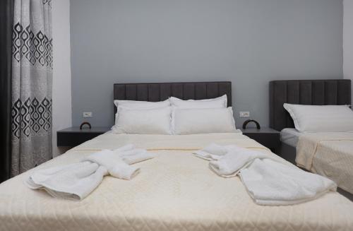 a bed with two white towels on top of it at Berat Central Apartment in Berat