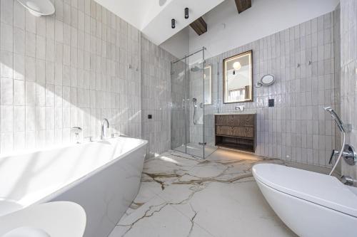 a bathroom with a tub and a toilet and a sink at Palanga Life Balance SPA Hotel in Palanga