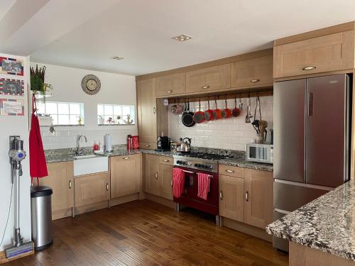 una cucina con armadi in legno e frigorifero in acciaio inossidabile di Marina View a Newcastle upon Tyne