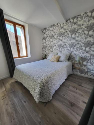 une chambre avec un lit avec un papier peint fleuri dans l'établissement Paisible maison de village avec terrasse, à Fleury