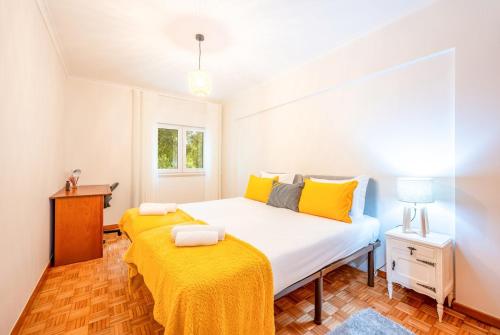 - une chambre avec un grand lit et des oreillers jaunes dans l'établissement GuestReady - A Cosy Retreat in Lumiar, à Lisbonne