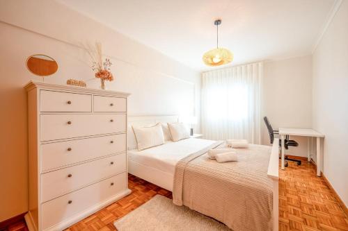 - une chambre avec un lit blanc et une commode dans l'établissement GuestReady - A Cosy Retreat in Lumiar, à Lisbonne