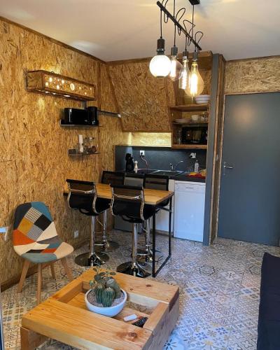 une cuisine avec une table, des chaises et un comptoir dans l'établissement Le Pélican, à Saint-Georges-de-Didonne