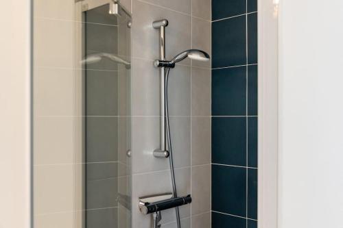 une douche dans une salle de bain avec une porte vitrée dans l'établissement Sunset, à Saint-Malo