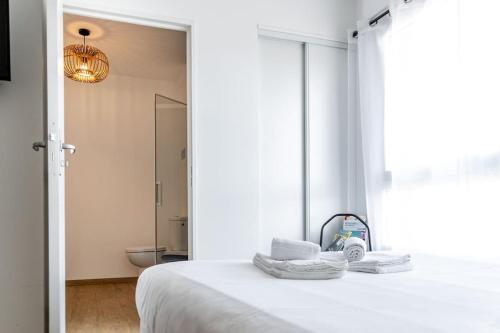 - une chambre blanche avec un lit et une salle de bains dans l'établissement Sunset, à Saint-Malo