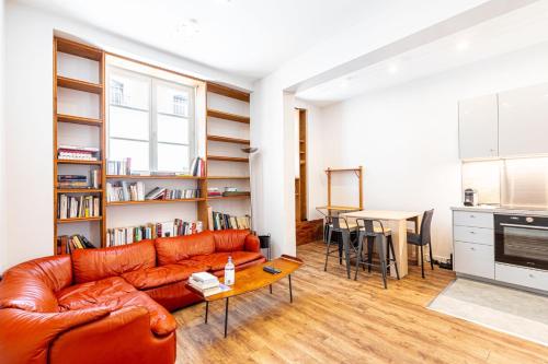 un salon avec un canapé en cuir et une table dans l'établissement GuestReady - Confort Moderne près des Invalides, à Paris