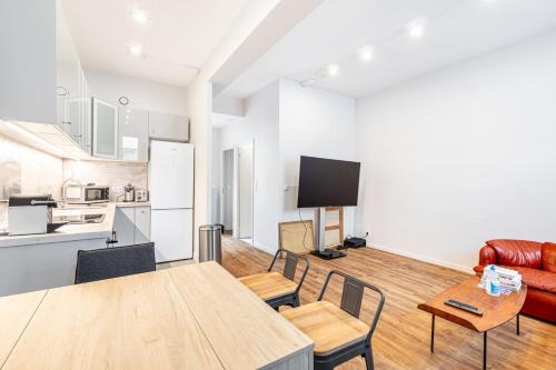 une cuisine et un salon avec une table et des chaises dans l'établissement GuestReady - Confort Moderne près des Invalides, à Paris