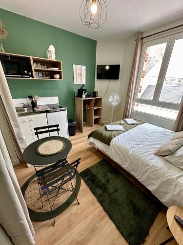 une chambre avec un lit, une table et un bureau dans l'établissement Le Vert-Tige - Gare - BCLA, au Mans