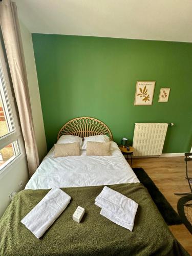 - une chambre verte avec un lit et des serviettes dans l'établissement Le Vert-Tige - Gare - BCLA, au Mans