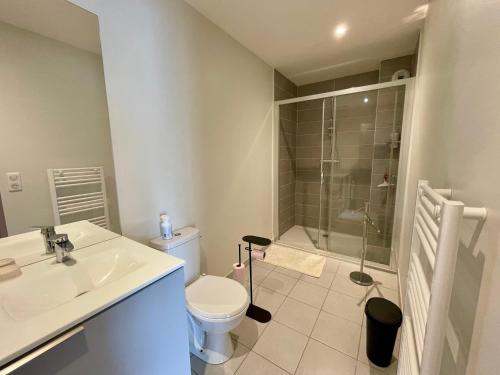 une salle de bain avec un lavabo, des toilettes et une douche dans l'établissement Charmant Appartement au Coeur de l'Avenue Lajarige, à La Baule