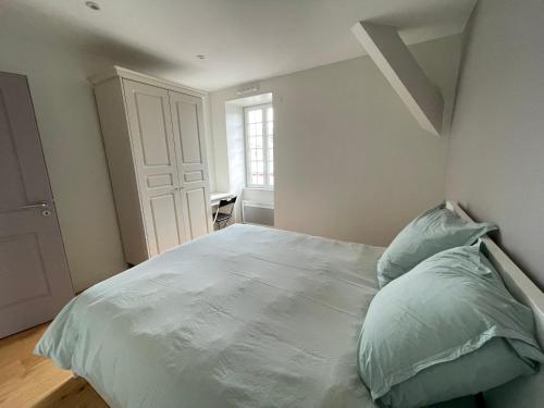 une chambre avec un grand lit blanc avec une fenêtre dans l'établissement Charmant Appartement au Coeur de l'Avenue Lajarige, à La Baule