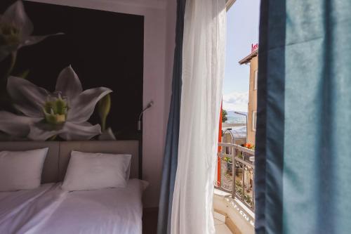 1 dormitorio con cama y vistas a un balcón en AMMOTTI Hotel and Apartments en Ohrid