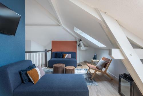 sala de estar con sofá azul y sillas en Best Western Bridge Hotel Lyon East en Jons