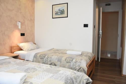 a hotel room with two beds and a hallway at Hotel "Srbija Tis" in Zaječar