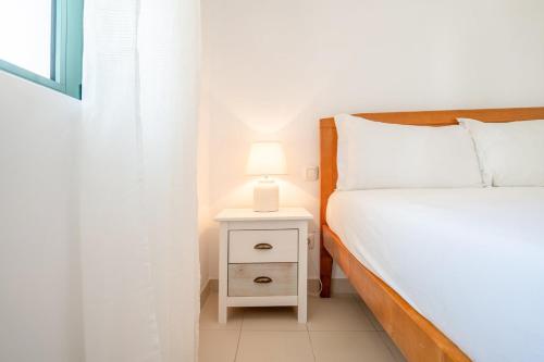een slaapkamer met een bed en een nachtkastje met een lamp bij GuestReady - Relaxation near Carcavelos Beach in Carcavelos
