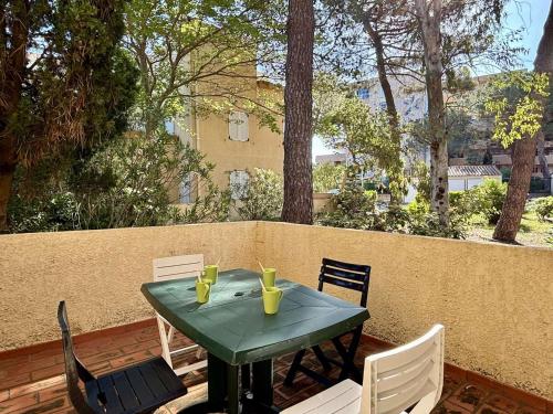 une table et des chaises vertes sur la terrasse dans l'établissement Appartement 2 pièces avec terrasse et parking, à 80m de la plage, proche commerces, pour 4 pers. - FR-1-225-252, à Argelès-sur-Mer