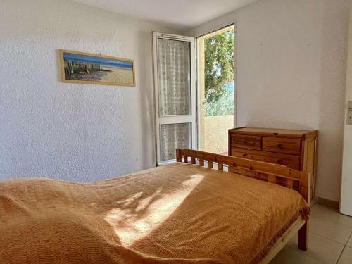 une chambre avec un lit, une commode et une fenêtre dans l'établissement Appartement 2 pièces avec terrasse et parking, à 80m de la plage, proche commerces, pour 4 pers. - FR-1-225-252, à Argelès-sur-Mer