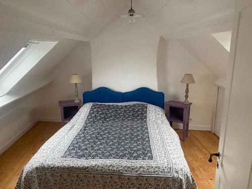 - une chambre mansardée avec un lit bleu dans l'établissement Charmante maison proche plage à Locmaria, 4 pers, jardin, cheminée, équipements complets - FR-1-418-97, à Locmaria