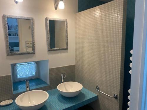 une salle de bain avec deux lavabos et deux miroirs dans l'établissement Charmante maison proche plage à Locmaria, 4 pers, jardin, cheminée, équipements complets - FR-1-418-97, à Locmaria