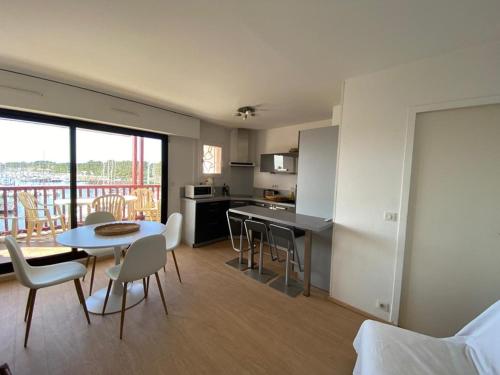 une cuisine et un salon avec une table et des chaises dans l'établissement Appartement climatisé pour 4 avec balcon et parking à Capbreton - FR-1-413-101, à Capbreton