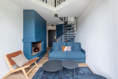 a living room with a blue couch and a table at Best Western Bridge Hotel Lyon East in Jons