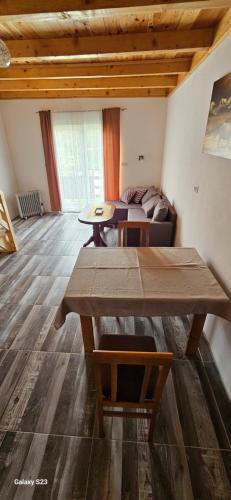 a living room with a table and a couch at Apartmani JEZERO in Žabljak