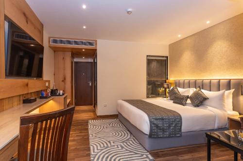 a hotel room with a bed and a desk at The Belvedere Himalayan Retreat, Mcleodganj, Dharamshala - By Leisure Hotels in McLeod Ganj