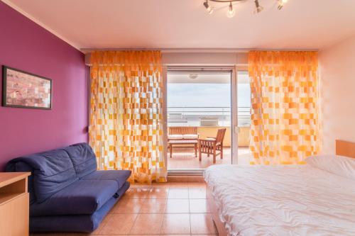 1 dormitorio con 1 cama, 1 silla y balcón en Apartments M, en Split