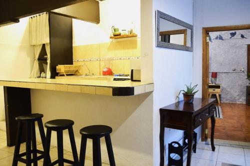 a kitchen with stools and a counter with a table at Espacioso moderno y bien ubicado in Oaxaca City