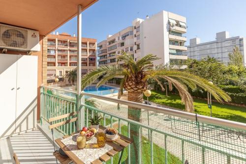 Un balcón con una mesa y una palmera en Cozy stay in Pobla Farnals - 15 min from Valencia, en La Pobla de Farnals