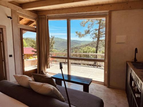 a living room with a couch and a large window at Cabañas Agotzenea in Zubiri