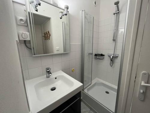 une salle de bain blanche avec un lavabo et une douche dans l'établissement Studio Moderne - Proche Plage - Parking - FR-1-324A-47, à Saint-Hilaire-de-Riez