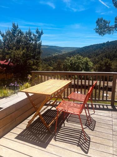a wooden table and two chairs sitting on a deck at Cabañas Agotzenea in Zubiri