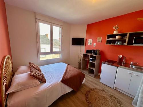 - une chambre avec des murs orange, un lit et une fenêtre dans l'établissement Le TerraCosy - Gare - BCLA, au Mans