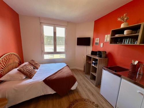 - une chambre avec des murs orange, un lit et une fenêtre dans l'établissement Le TerraCosy - Gare - BCLA, au Mans