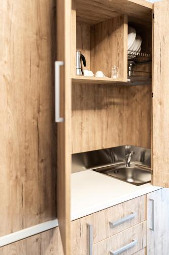 a kitchen with a sink and wooden cabinets at M-APPHOTEL in Benna