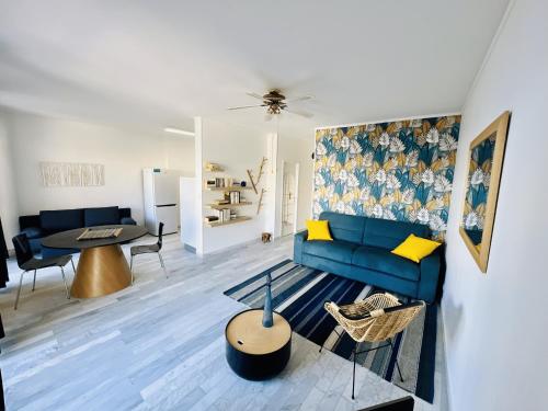 un salon avec un canapé bleu et une table dans l'établissement Grand Studio terrasse vue sur mer et parking, à Ajaccio