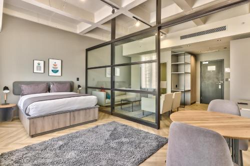 a bedroom with a bed and a table and chairs at WINK Aparthotel One Thibault in Cape Town