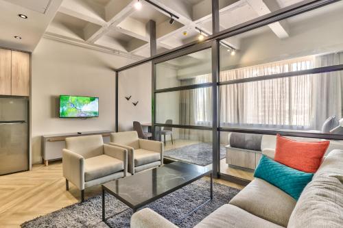 a living room with a couch and chairs at WINK Aparthotel One Thibault in Cape Town