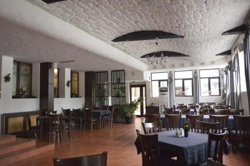 a dining room with tables and chairs and windows at Persey Flora Apartments in Borovets