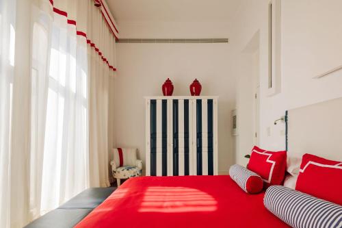a bedroom with a red bed with two red pillows at Bela Vista Hotel & Spa - Relais & Chateaux in Portimão