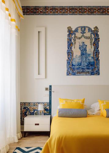 a bedroom with a yellow bed and a painting on the wall at Bela Vista Hotel & Spa - Relais & Chateaux in Portimão