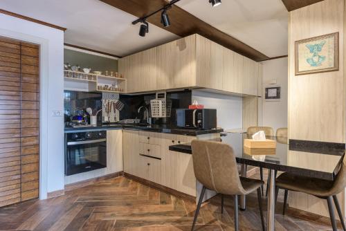 a kitchen with wooden cabinets and a table and chairs at Bubble Faraya With Terrasse Next To Ski-Slopes in Fārayyā