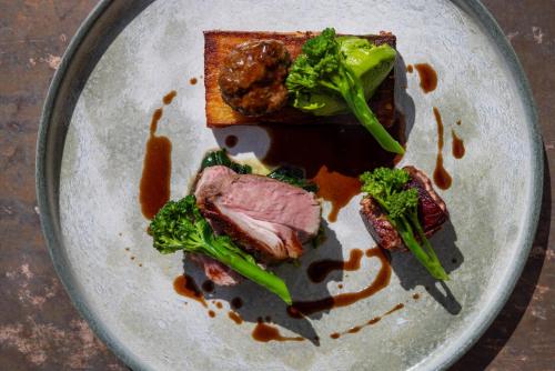 a plate of food with broccoli and meat on it at The Haughmond in Shrewsbury