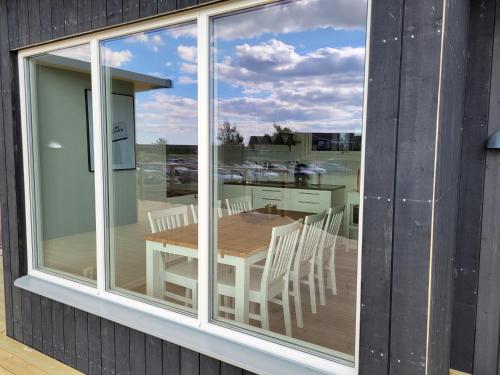 a glass window of a house with a table and chairs at Halmstad Golfarena stugor in Halmstad